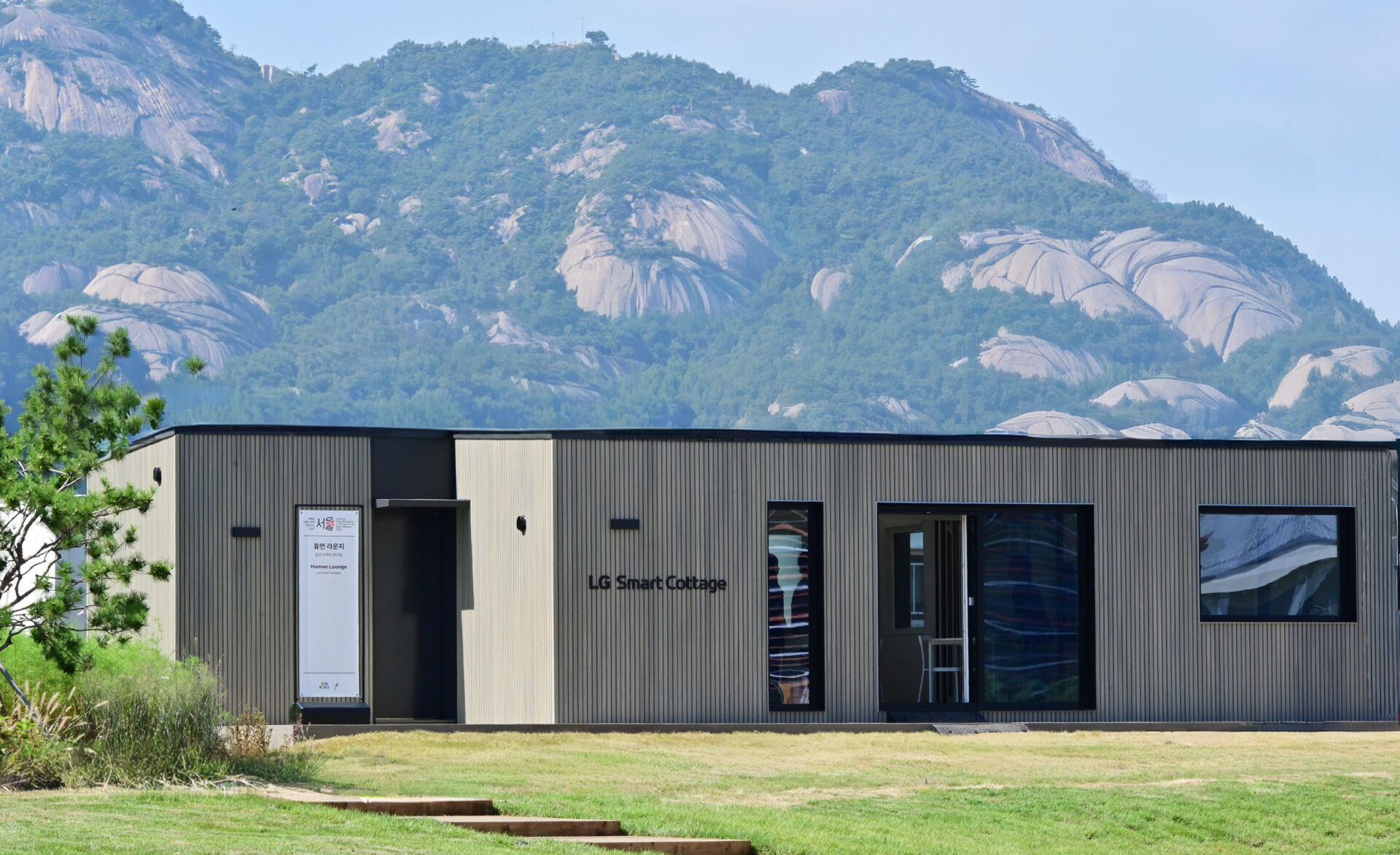 LG 스마트코티지를 중심으로 뒤쪽에는 산이, 앞쪽에는 정원이 펼쳐 있습니다.