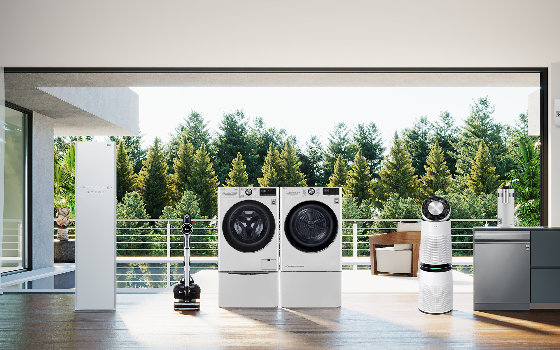 창 밖으로 울창한 나무 숲이 있는 베란다 앞에 세탁기와 건조기, 무선청소기 등이 나란히 놓여 있는 모습